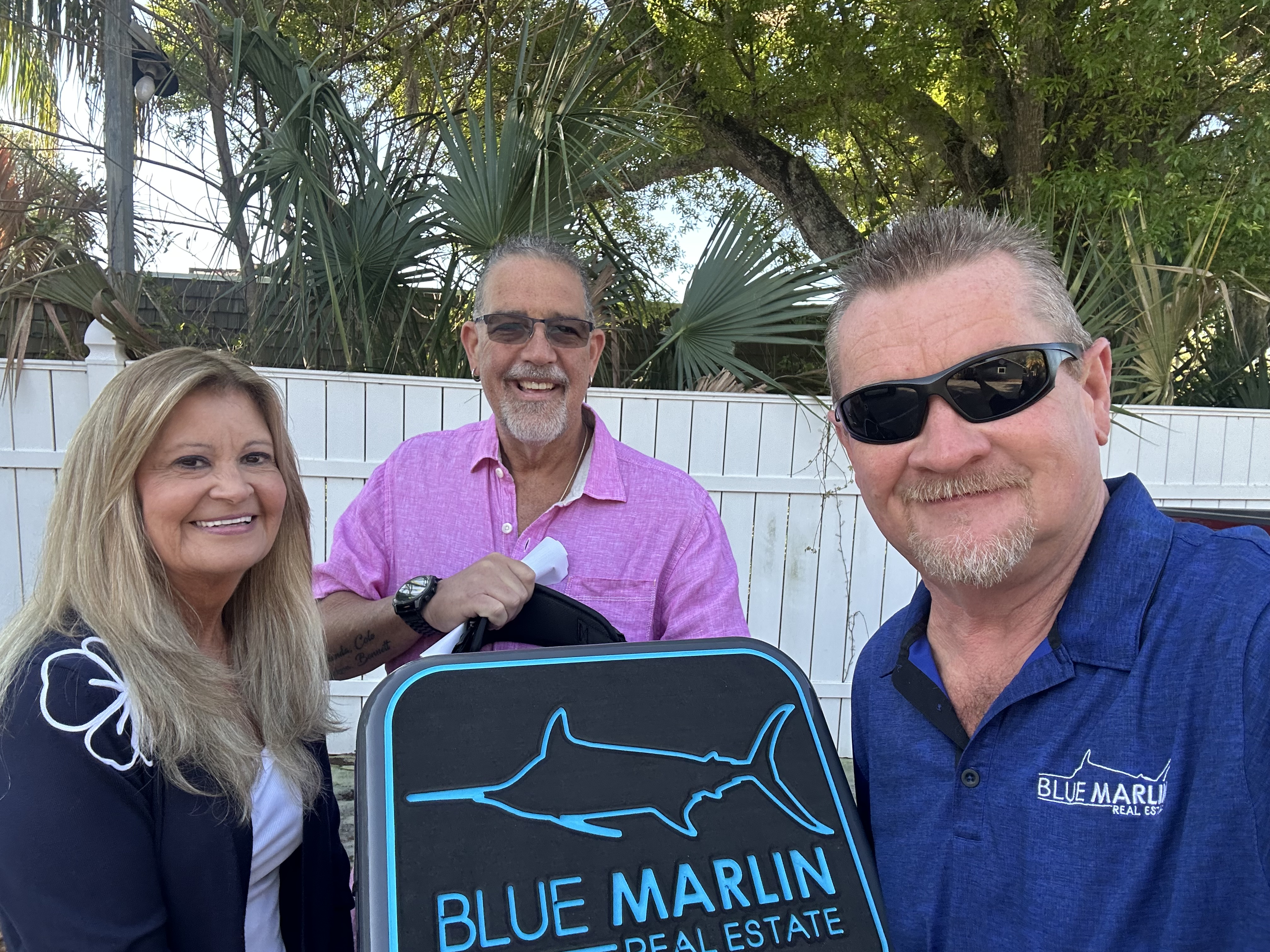 Blue Marlin Real Estate team standing with a property sign